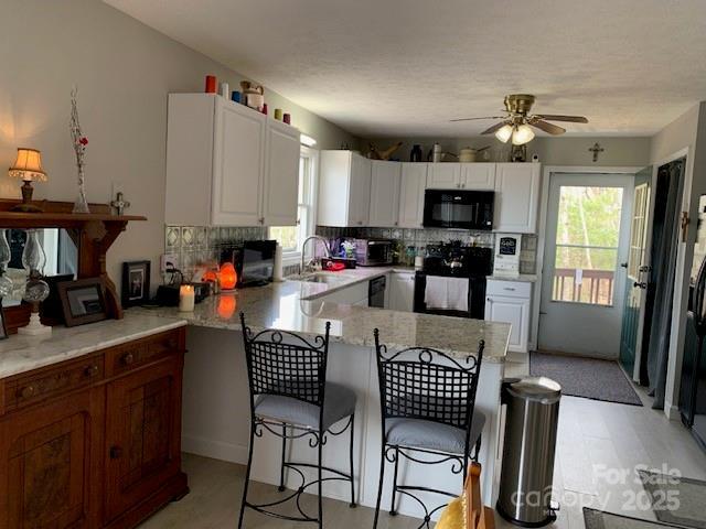 1474 Holiday Drive 14 & 15, Hendersonville, NC 28739 - kitchen featuring range, black microwave, a kitchen bar, ceiling fan, and a peninsula