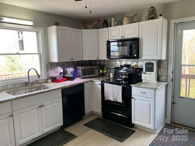1474 Holiday Drive 14 & 15, Hendersonville, NC 28739 - kitchen featuring black appliances, a sink, white cabinets, backsplash, and light stone counters