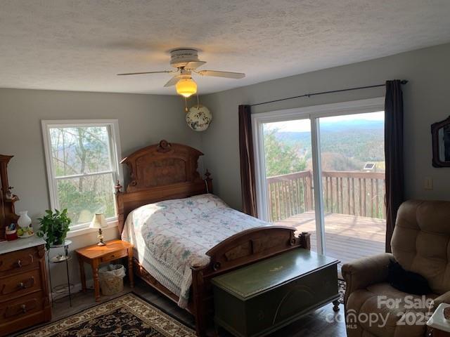 1474 Holiday Drive 14 & 15, Hendersonville, NC 28739 - bedroom featuring access to exterior, multiple windows, a ceiling fan, wood finished floors, and a textured ceiling