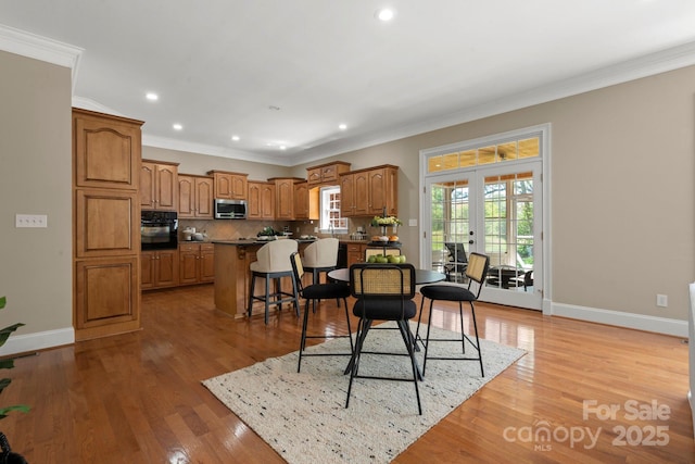 dining space featuring recessed lighting, baseboards, ornamental molding, and light wood-style flooring