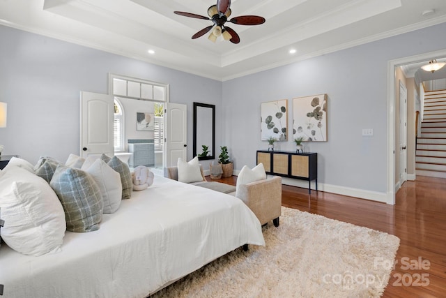 bedroom with recessed lighting, a raised ceiling, wood finished floors, and ornamental molding