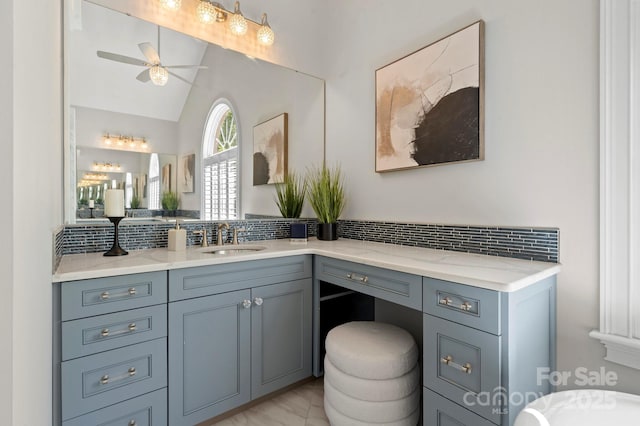 bathroom featuring ceiling fan, lofted ceiling, tasteful backsplash, and vanity