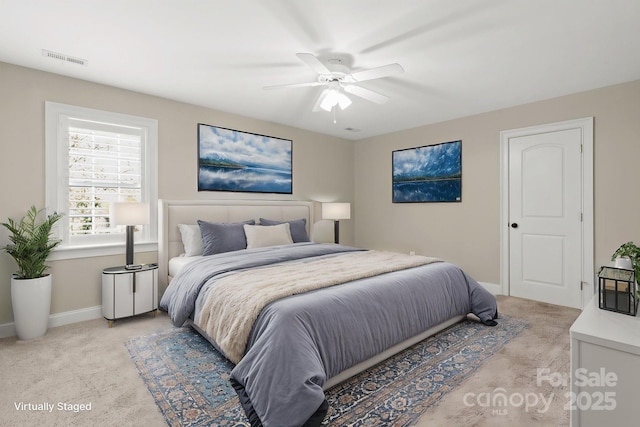 bedroom featuring ceiling fan, light carpet, visible vents, and baseboards