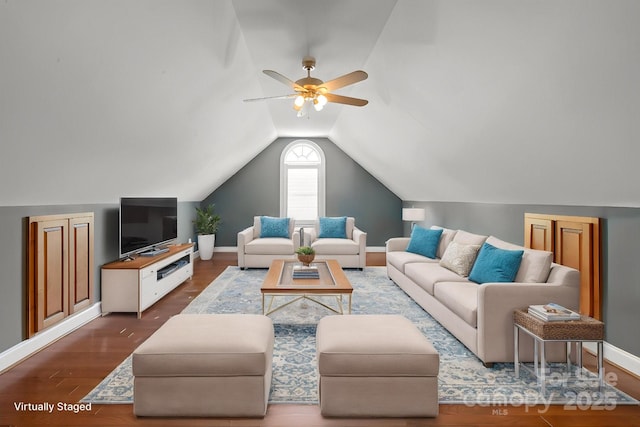 living area with ceiling fan, vaulted ceiling, wood finished floors, and baseboards