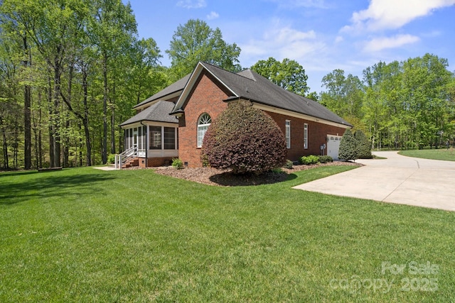 view of home's exterior featuring a lawn, driveway, brick siding, and roof with shingles