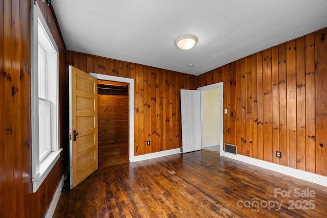 67 Montana Ave, Asheville, NC 28806 - unfurnished bedroom featuring wood walls, visible vents, hardwood / wood-style flooring, and baseboards