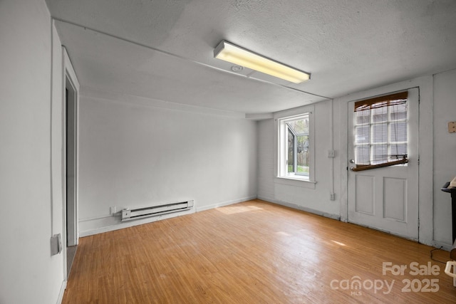 67 Montana Ave, Asheville, NC 28806 - empty room with baseboards, a baseboard radiator, a textured ceiling, and wood finished floors
