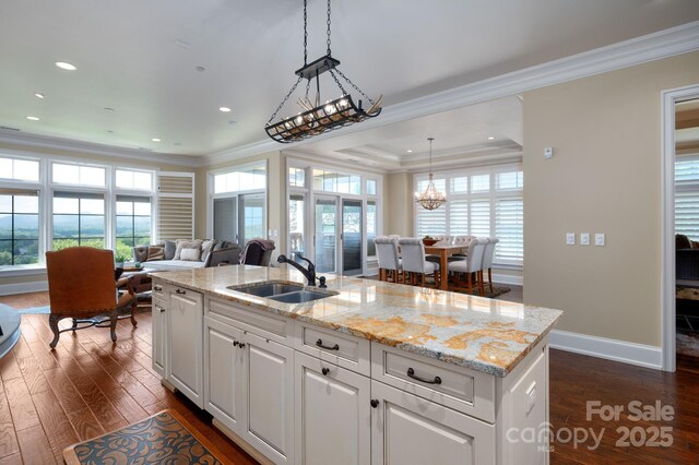 288 Macon Ave Unit 108, Asheville, NC 28804 - kitchen featuring crown molding, dark wood finished floors, a sink, a notable chandelier, and white cabinetry