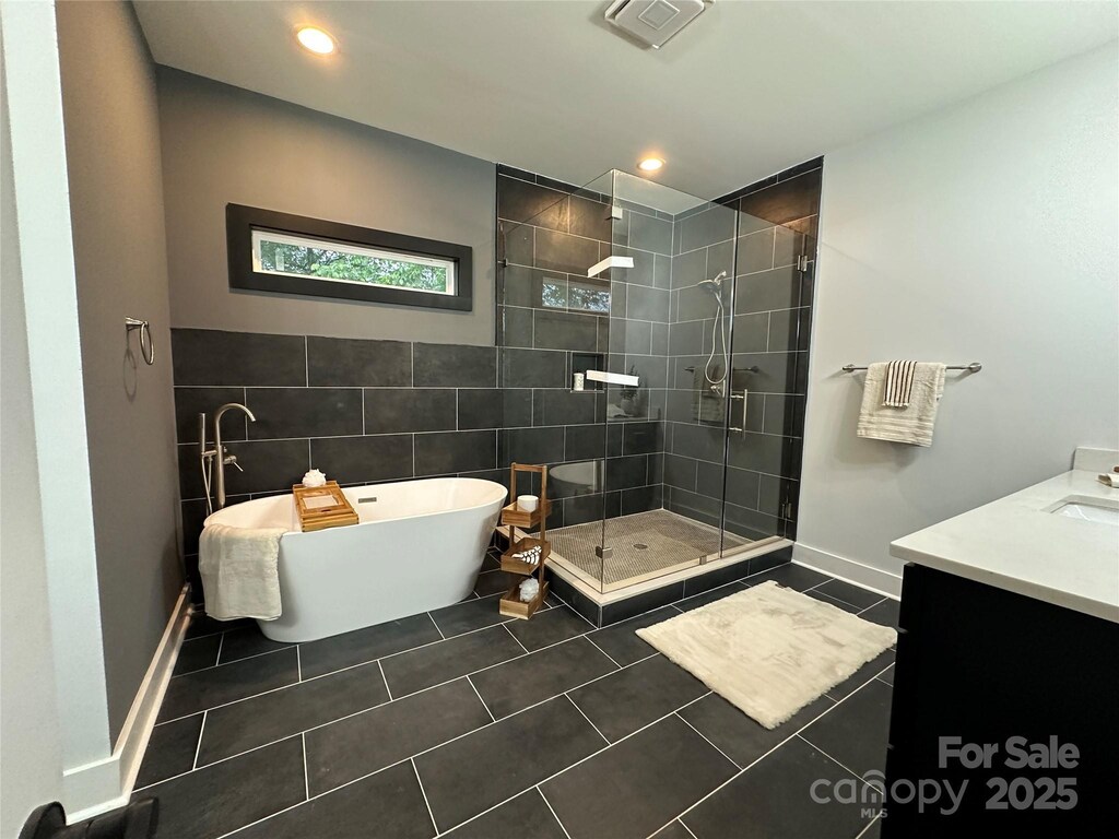 12069 Coyle Rd, Stanfield, NC 28163 - full bath with a tile shower, vanity, visible vents, a freestanding bath, and tile patterned floors