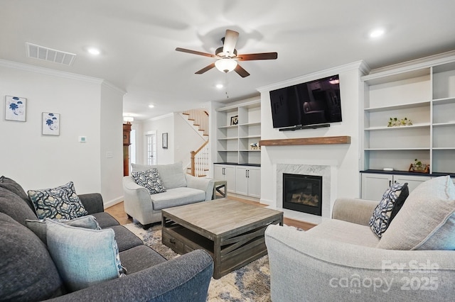4120 Spring Cove Way, Belmont, NC 28012 - living area with crown molding, stairs, ceiling fan, a premium fireplace, and visible vents