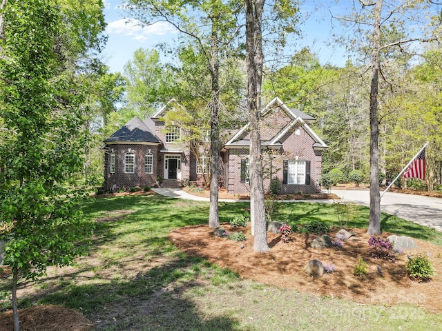 view of front facade featuring brick siding and a front lawn