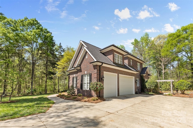 view of home's exterior featuring a shingled roof, a yard, an attached garage, concrete driveway, and brick siding