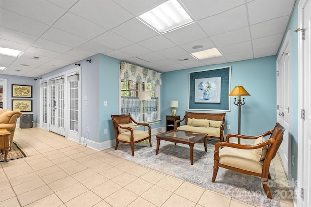 interior space with a paneled ceiling, baseboards, and tile patterned flooring