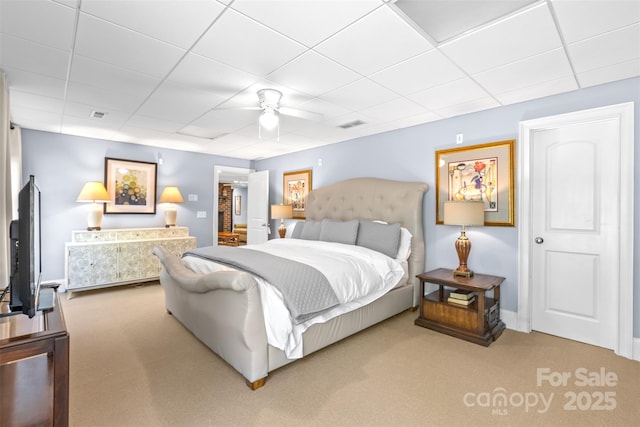 carpeted bedroom featuring a paneled ceiling, ceiling fan, and a spacious closet