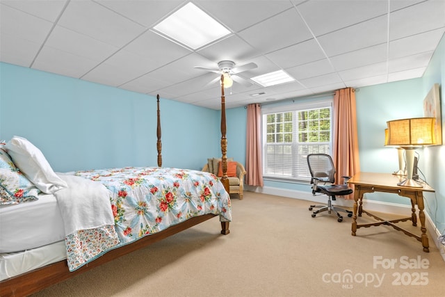 carpeted bedroom featuring baseboards, a ceiling fan, and a paneled ceiling