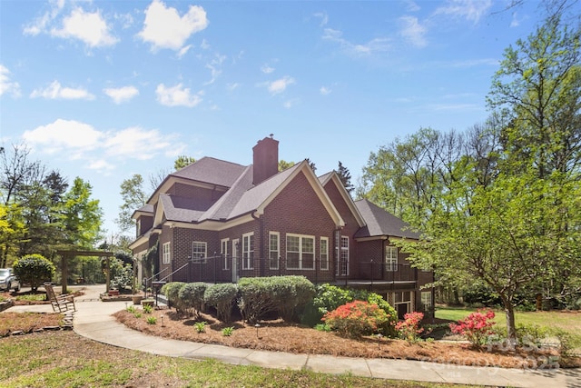 exterior space featuring a pergola, brick siding, and a chimney