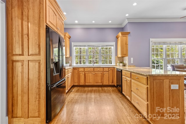 kitchen featuring light stone counters, a peninsula, crown molding, light wood-style floors, and black appliances