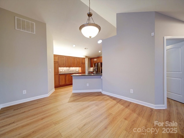 4754 Polo Gate Blvd, Charlotte, NC 28216 - kitchen with visible vents, dark countertops, lofted ceiling, light wood-style floors, and freestanding refrigerator