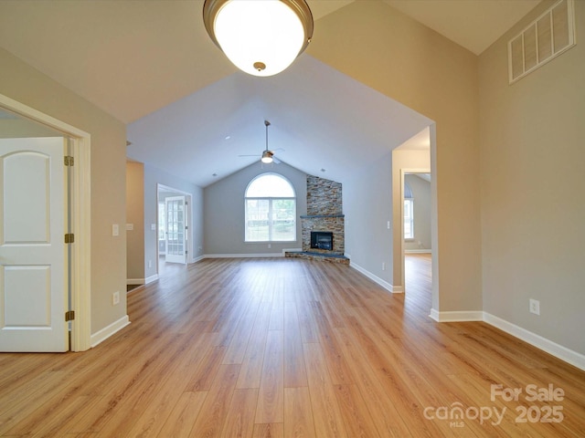 4754 Polo Gate Blvd, Charlotte, NC 28216 - unfurnished living room with visible vents, ceiling fan, a stone fireplace, light wood-type flooring, and vaulted ceiling