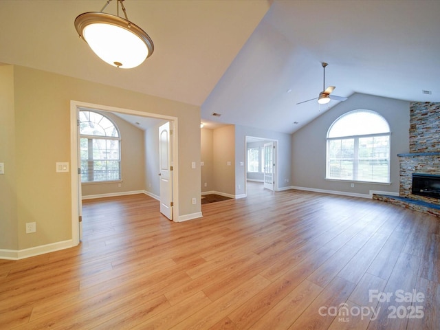4754 Polo Gate Blvd, Charlotte, NC 28216 - unfurnished living room featuring lofted ceiling, light wood-style flooring, baseboards, a ceiling fan, and a stone fireplace