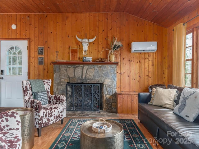 living room featuring lofted ceiling, a wall mounted air conditioner, plenty of natural light, wood finished floors, and wooden ceiling