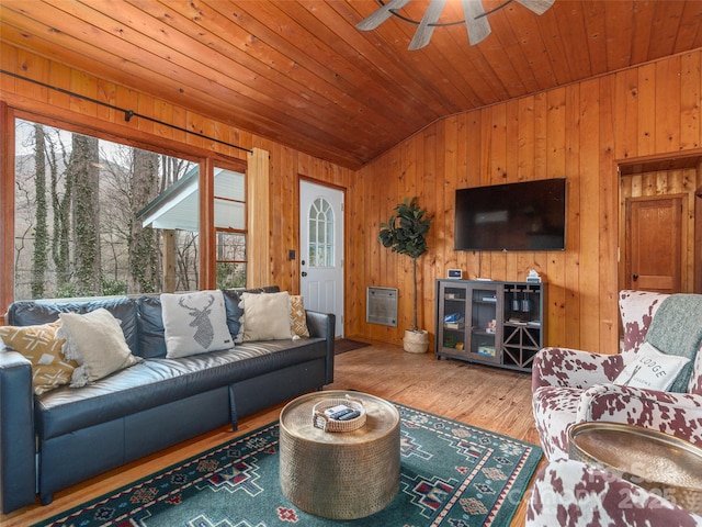 living room featuring vaulted ceiling, a ceiling fan, wood finished floors, wooden walls, and wood ceiling
