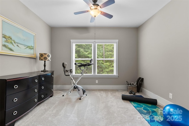 exercise room with a ceiling fan, baseboards, and carpet