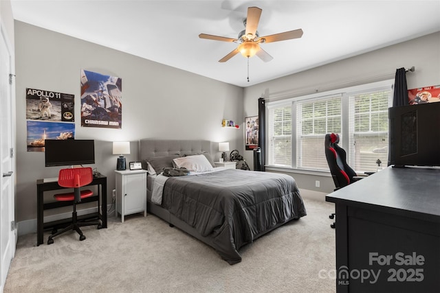bedroom featuring ceiling fan, light colored carpet, and baseboards