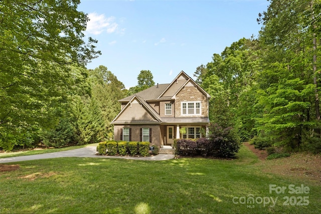 craftsman-style home featuring stone siding and a front yard