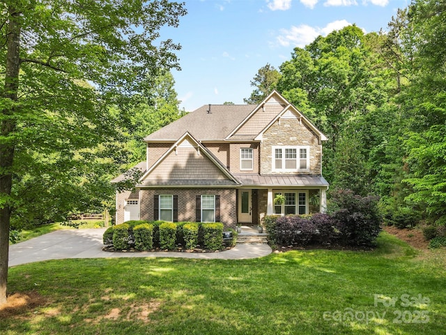 craftsman inspired home featuring a standing seam roof, an attached garage, driveway, and a front yard