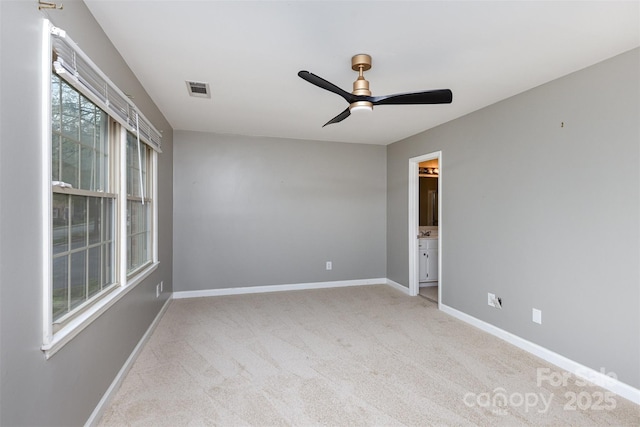unfurnished room featuring light carpet, baseboards, visible vents, and ceiling fan