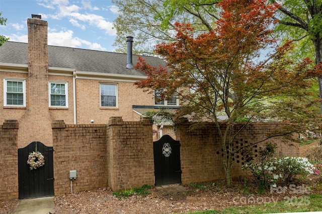 view of front of home with a shingled roof and a chimney