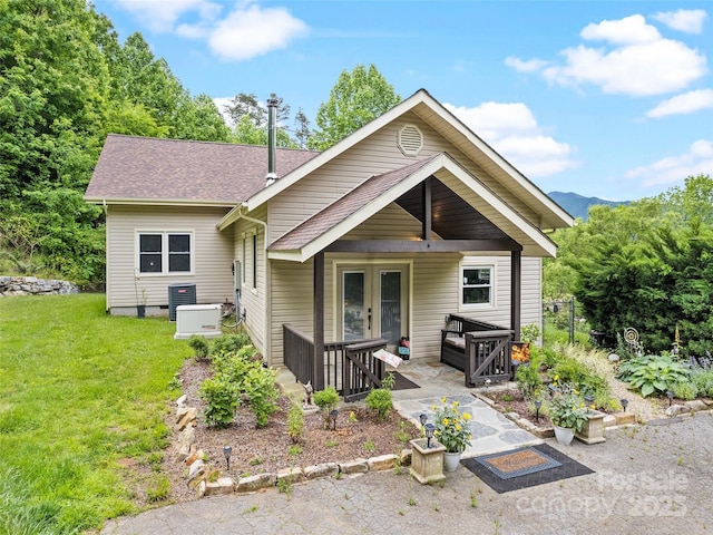 234 Bird Creek Dr, Waynesville, NC 28786 - view of front facade with a front yard, a patio area, central air condition unit, french doors, and a shingled roof