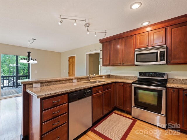 234 Bird Creek Dr, Waynesville, NC 28786 - kitchen featuring appliances with stainless steel finishes, a sink, a peninsula, and light wood-type flooring