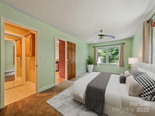 234 Bird Creek Dr, Waynesville, NC 28786 - bedroom featuring light colored carpet, baseboards, light tile patterned floors, and ceiling fan