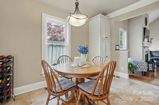 dining room featuring a healthy amount of sunlight, baseboards, and ornamental molding