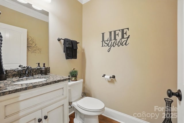 half bath with baseboards, wood finished floors, toilet, and vanity