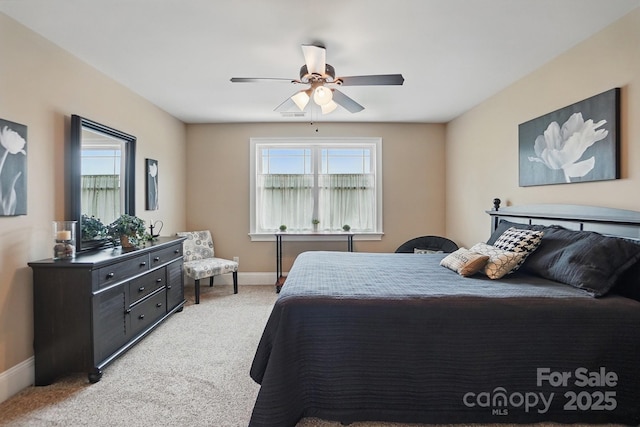 bedroom with a ceiling fan, baseboards, and light colored carpet