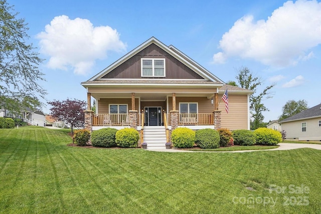 view of front of home featuring a front lawn, a porch, and stone siding