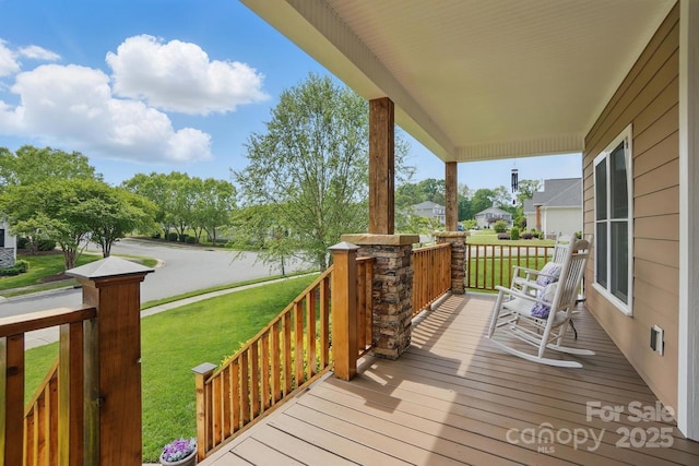 wooden deck with a yard and covered porch