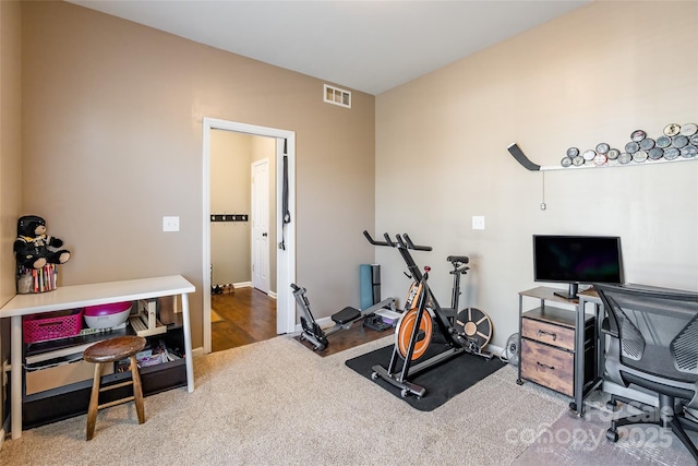 exercise room featuring visible vents, baseboards, and carpet floors