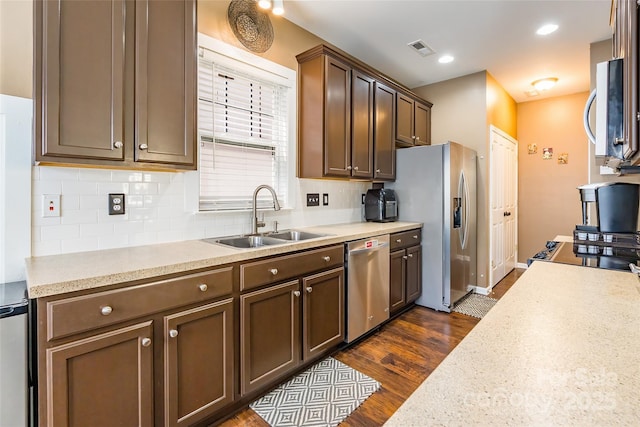 kitchen with tasteful backsplash, visible vents, a sink, light countertops, and stainless steel appliances