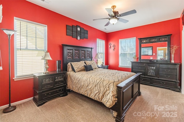 carpeted bedroom with ceiling fan, baseboards, and visible vents