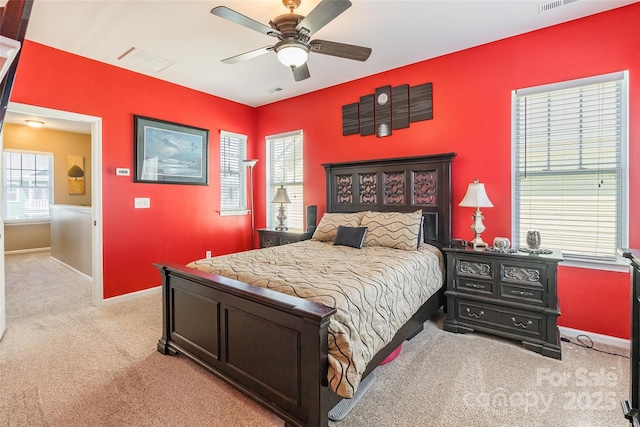 bedroom featuring light carpet, visible vents, baseboards, and a ceiling fan