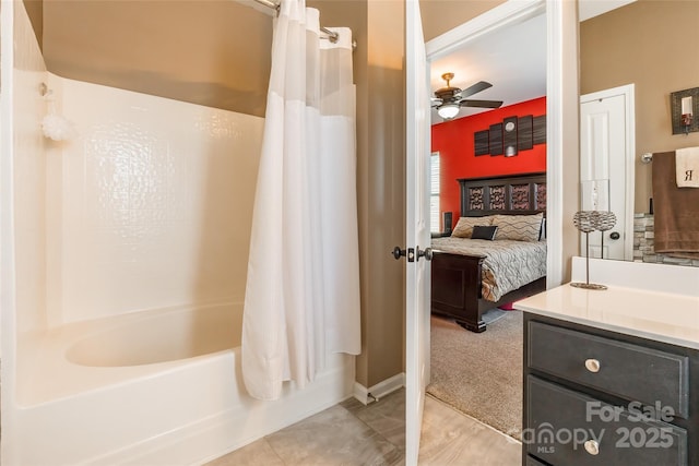 bathroom featuring shower / tub combo, baseboards, ceiling fan, ensuite bath, and vanity