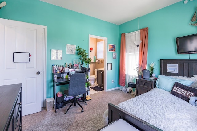 bedroom featuring ensuite bath, baseboards, and carpet floors
