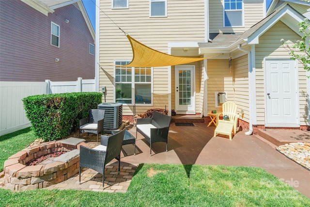 back of house with central air condition unit, an outdoor living space with a fire pit, fence, and a patio area
