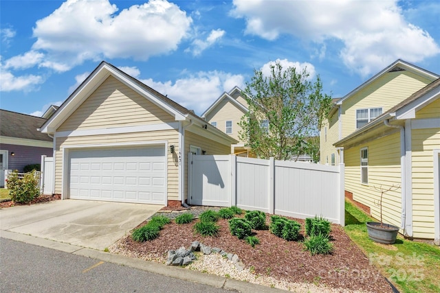 view of front of house with a garage, driveway, and fence