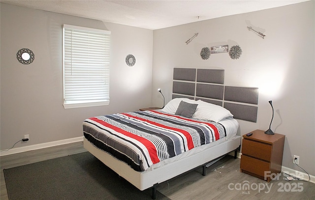 bedroom featuring baseboards and wood finished floors