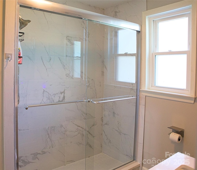 bathroom featuring a marble finish shower